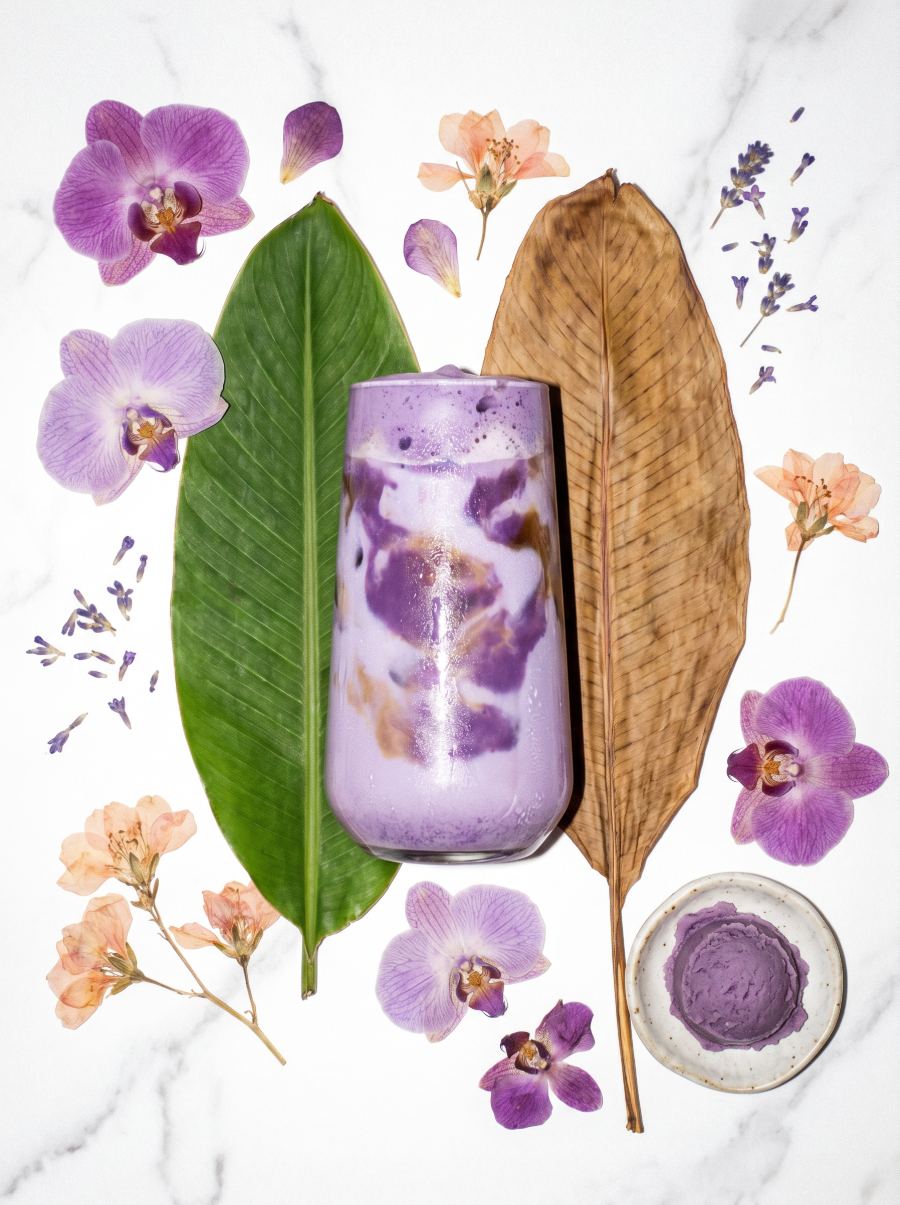 Ube Dream Latte styled with orchids and tropical leaves
